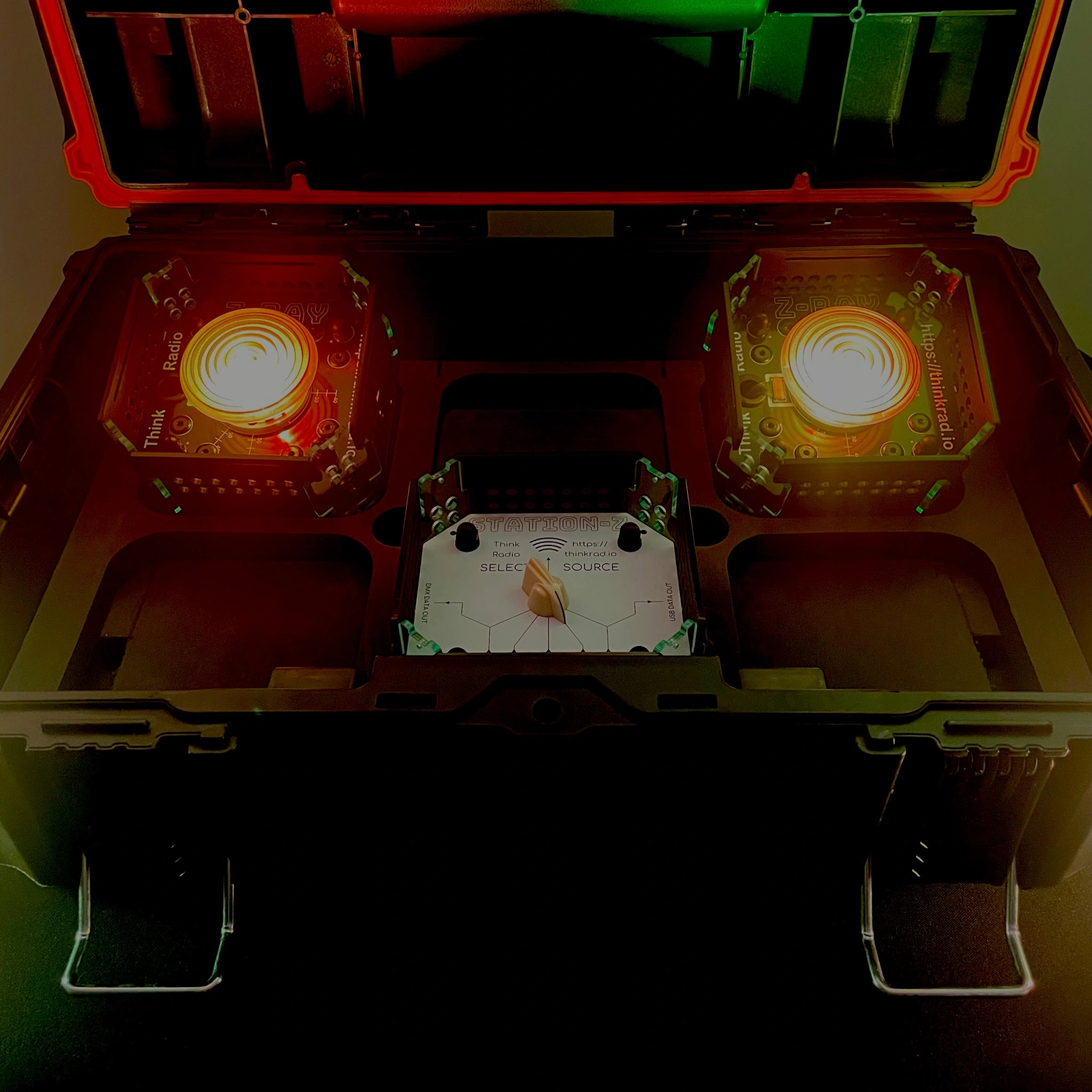Starter Kit consisting of 1 STATION-X and 2 Z-RAY's with Fresnel lenses, set to low-level illumination in yellowy-orange, all in a tough box.