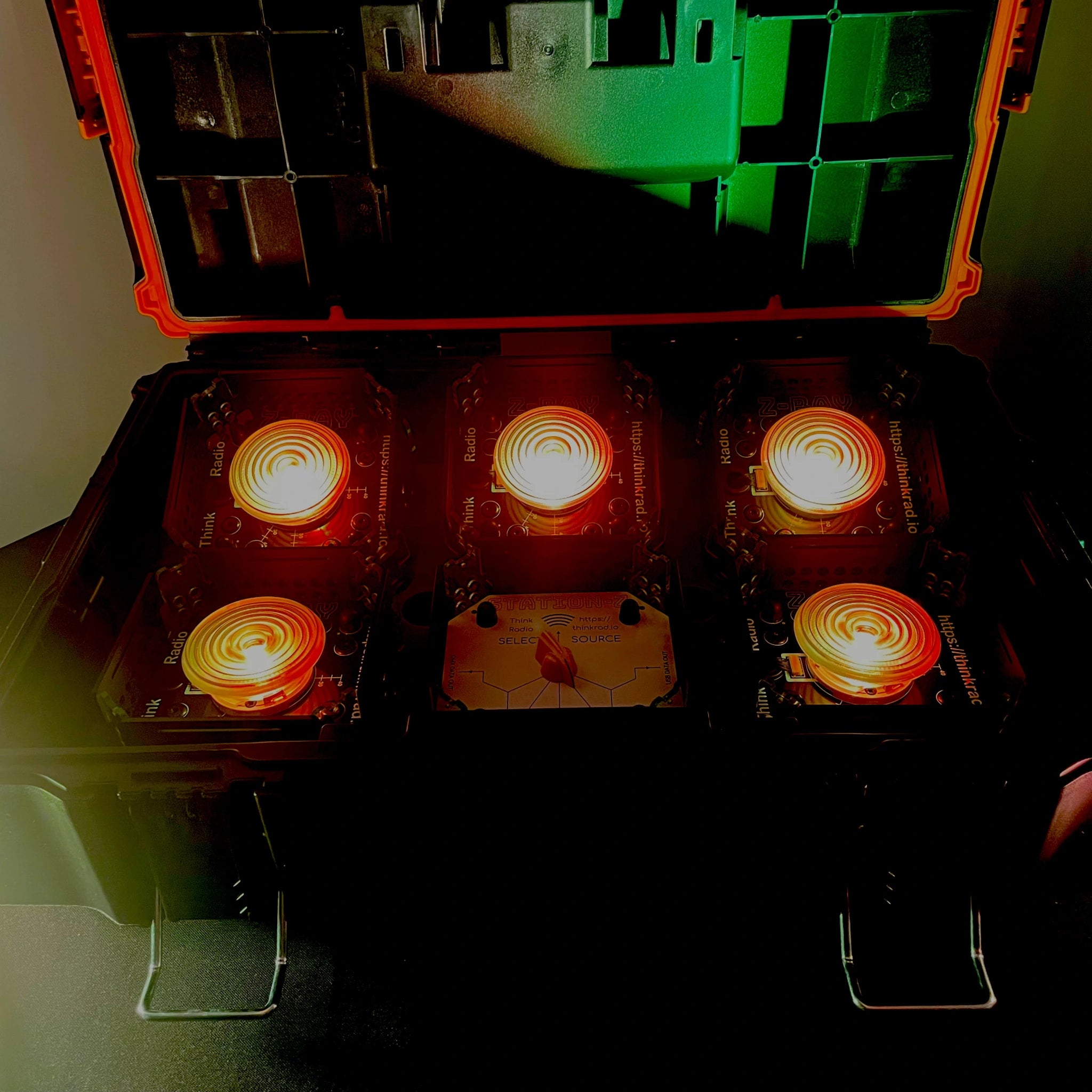 Starter Kit consisting of 1 STATION-X and 5 Z-RAY's with Fresnel lenses, set to low-level illumination in yellowy-orange, all in a tough box.